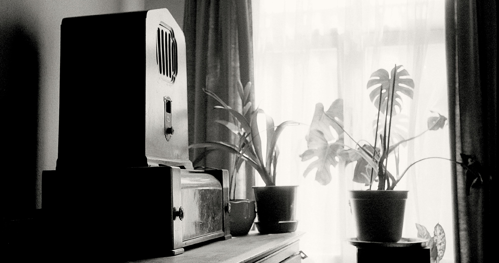 Old radio in the sunlight through a window curtain.
    